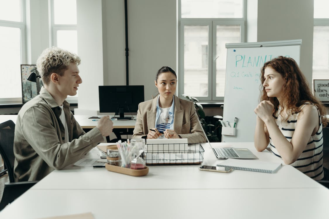 Colleagues talking during a meeting.
